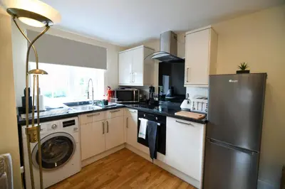 a kitchen with a refrigerator and a washer and dryer at Fennec Apartments in Cherry Hinton