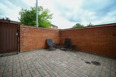 two chairs sitting next to a brick wall at Fennec Apartments in Cherry Hinton