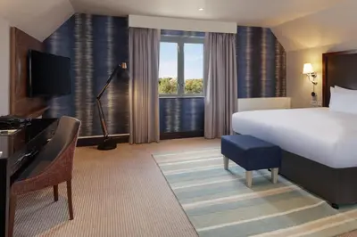 a hotel room with a bed and a large window at Cambridge Belfry Hotel & Spa in Cambridge