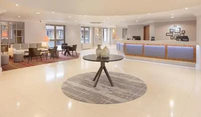 a lobby with a table with vases on it at Cambridge Belfry Hotel & Spa in Cambridge