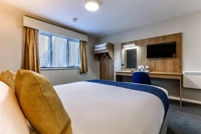 a hotel room with a bed and a television at Days Inn London Stansted Airport in Stansted Mountfitchet