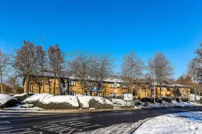 a street with snow on the side of a building at Days Inn London Stansted Airport in Stansted Mountfitchet