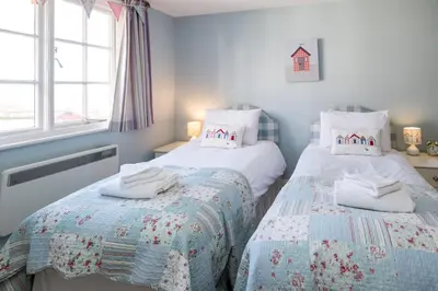 a bedroom with two beds and a window at Ogilvie Lodge Apartment in Thorpeness