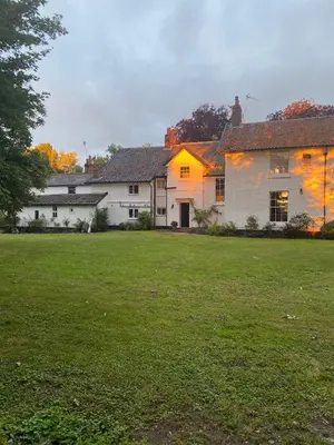 a white house with a green field in front of it at Old Rectory - Scoulton in Great Ellingham