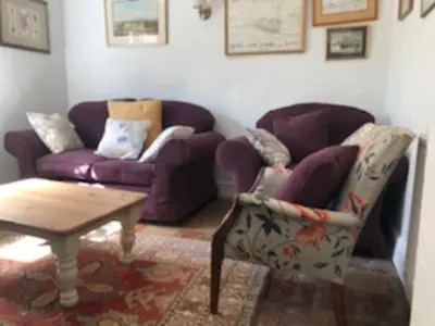 a living room with a purple couch and a table at Old Rectory - Scoulton in Great Ellingham