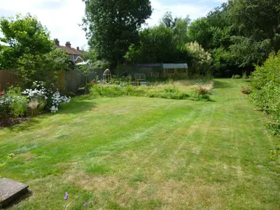 a yard with a large lawn with a fence at Golden Cross in Mendham