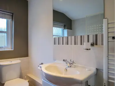 a bathroom with a sink and a toilet at Thimble Cottage - Aldeburgh Coastal Cottages in Aldeburgh