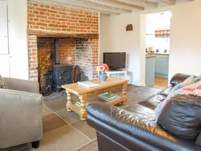 a living room with a couch and a fireplace at Thimble Cottage - Aldeburgh Coastal Cottages in Aldeburgh