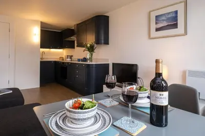 a table with a bottle of wine and a bowl of fruit at Boat Lake in Thorpeness
