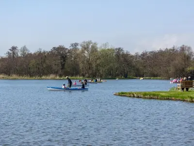 a group of people in boats on a lake at Boat Lake in Thorpeness