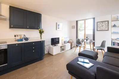 a kitchen and living room with a couch and a table at Boat Lake in Thorpeness