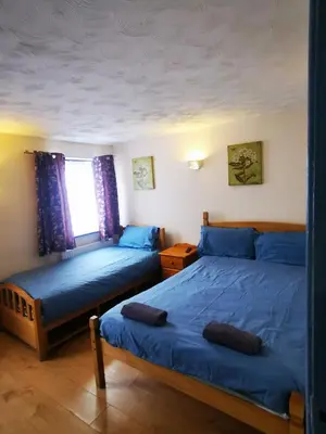 a bedroom with two beds and a window at The Oasis Hotel in Harlow