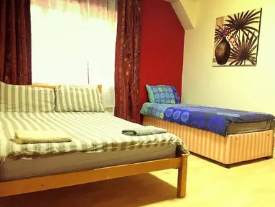 a room with two beds and a window at The Oasis Hotel in Harlow