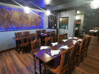 a dining room with wooden tables and wooden chairs at The Oasis Hotel in Harlow