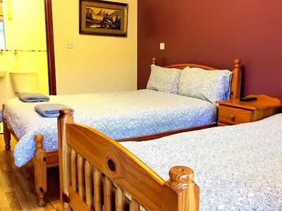 a bedroom with two twin beds and a mirror at The Oasis Hotel in Harlow