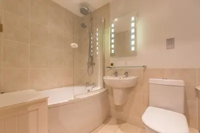 a bathroom with a toilet and a tub and a sink at Stones Throw in Aldeburgh