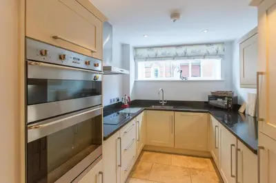 a kitchen with a sink and a stove top oven at Stones Throw in Aldeburgh