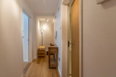 a hallway with a table and a door to a room at Stones Throw in Aldeburgh
