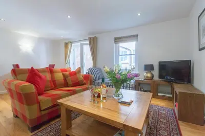 a living room with a couch and a table at Stones Throw in Aldeburgh