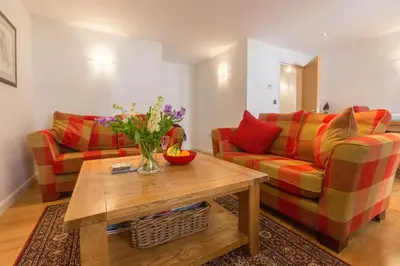 a living room with two couches and a coffee table at Stones Throw in Aldeburgh