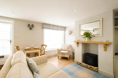 a living room with a couch and a fireplace at The Old Custom House in Aldeburgh