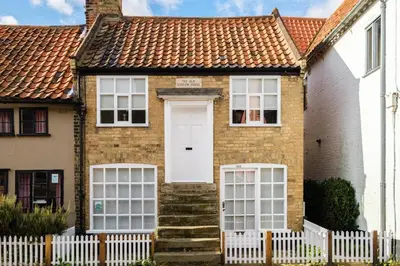 a house with a white door and a fence at The Old Custom House in Aldeburgh