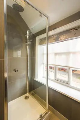 a glass shower in a bathroom with a window at The Old Custom House in Aldeburgh