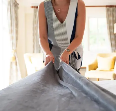 a woman standing in a room with a pillow at Thorpeness Golf Club and Hotel in Thorpeness
