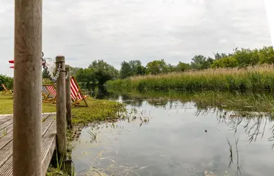 a body of water next to a wooden fence at Thorpeness Golf Club and Hotel in Thorpeness