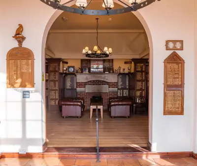 an archway leading into a library with a table and chairs at Thorpeness Golf Club and Hotel in Thorpeness
