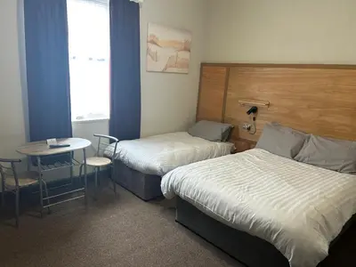 a hotel room with two beds and a table and a window at Royal Albion Walton in Walton-on-the-Naze