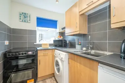 a kitchen with a sink and a dishwasher at 17 Britten Close - Aldeburgh Coastal Cottages in Aldeburgh