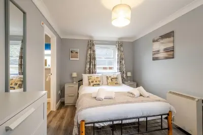 a bedroom with a bed with white sheets and pillows at 17 Britten Close - Aldeburgh Coastal Cottages in Aldeburgh