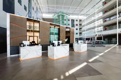 a large room with three white tables in a building at Radisson Blu Hotel London Stansted Airport in Stansted Mountfitchet