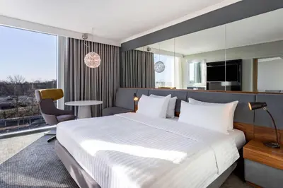 a bedroom with a large bed and a large window at Radisson Blu Hotel London Stansted Airport in Stansted Mountfitchet