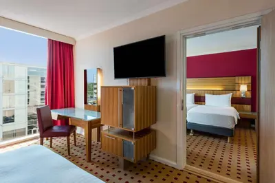 a hotel room with a bed and a desk with a television at Radisson Blu Hotel London Stansted Airport in Stansted Mountfitchet