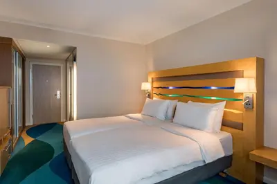 a hotel room with a bed with white sheets and pillows at Radisson Blu Hotel London Stansted Airport in Stansted Mountfitchet