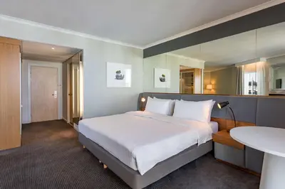 a bedroom with a large white bed and a table at Radisson Blu Hotel London Stansted Airport in Stansted Mountfitchet