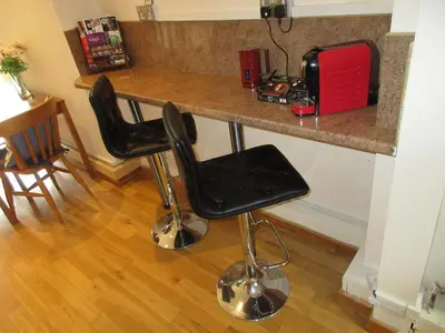 a kitchen with a counter with two black bar stools at Shear Annexe Flat in Cambridge