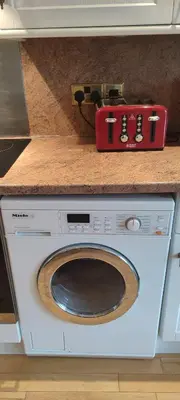 a washing machine with a red box on top of it at Shear Annexe Flat in Cambridge