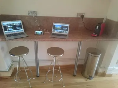 two laptops sitting on a counter with two stools at Shear Annexe Flat in Cambridge