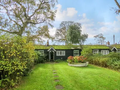 a house with a grass yard in front of it at 7 The Uplands in Thorpeness