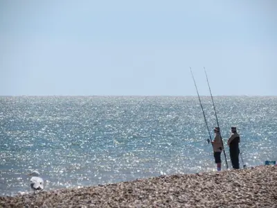 two people standing on a beach holding a fish at 7 The Uplands in Thorpeness