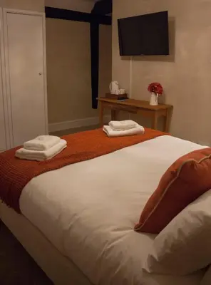 a bedroom with a bed with two towels on it at The Swan Hotel Bar and Grill in Maldon