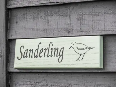a sign on a wall with a bird on it at Sanderling Home in Aldeburgh