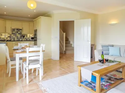 a kitchen and living room with a table and chairs at Sanderling Home in Aldeburgh