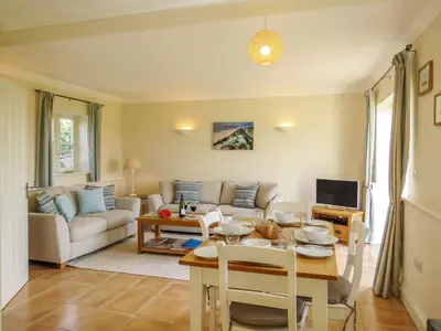 a living room with a table and a couch at Sanderling Home in Aldeburgh