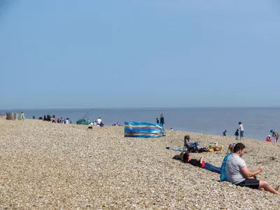 a group of people sitting on the beach at Walnut Cottage in Aldeburgh