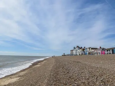 a sandy beach with houses and the ocean at Walnut Cottage in Aldeburgh