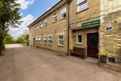 a brick building with a bench in front of it at Shelford Lodge in Cambridge